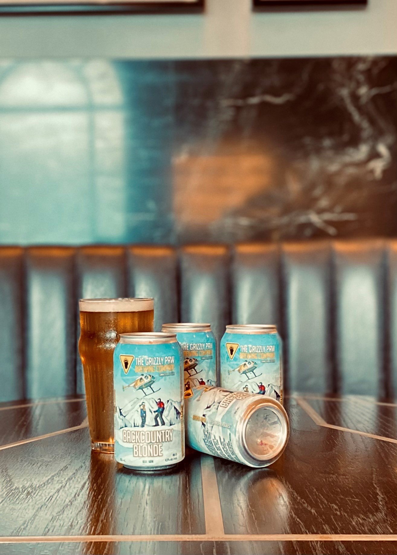 Cans of Backcountry Blonde Beer on table
