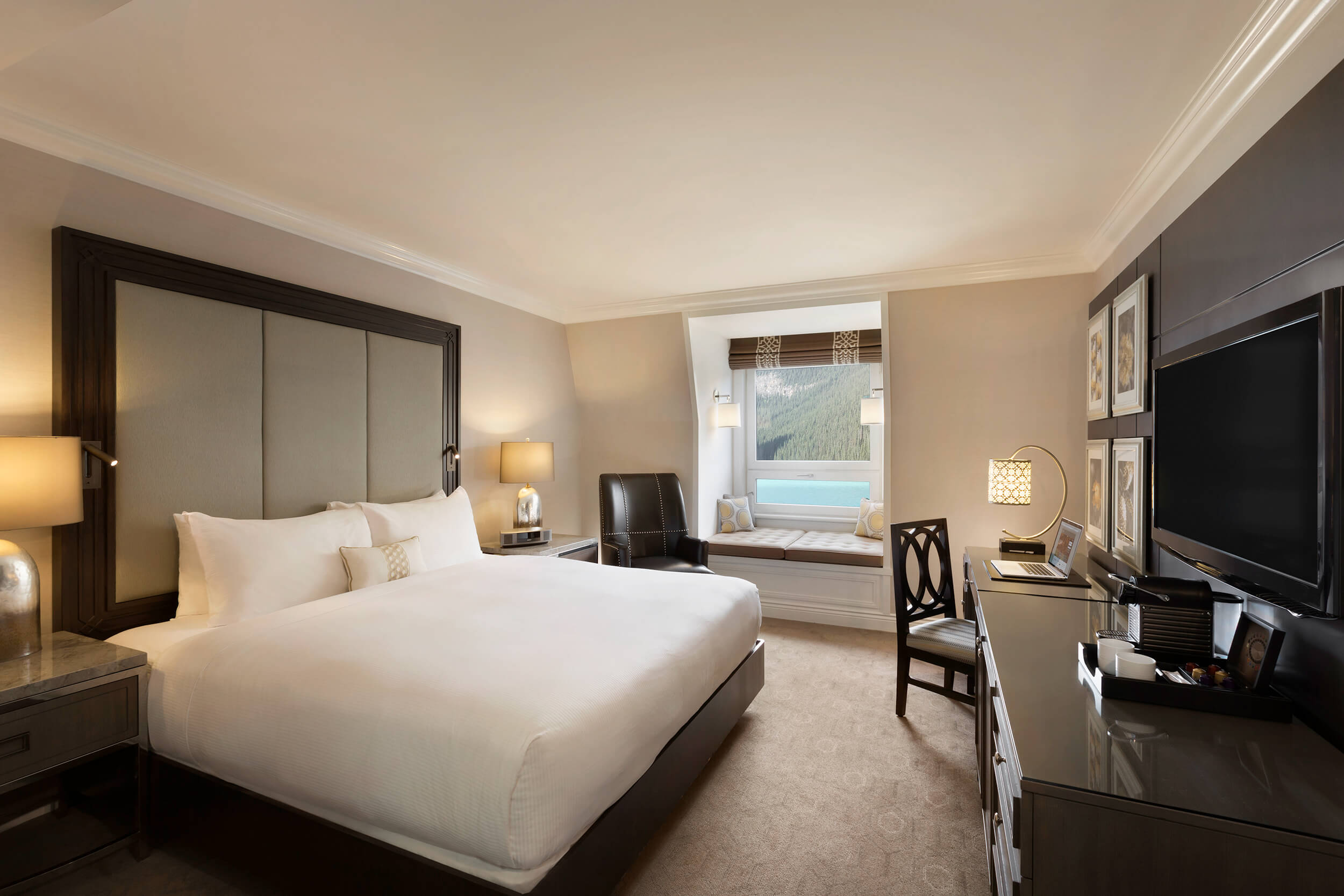 bedroom with bed and chair that overlooks lake louise