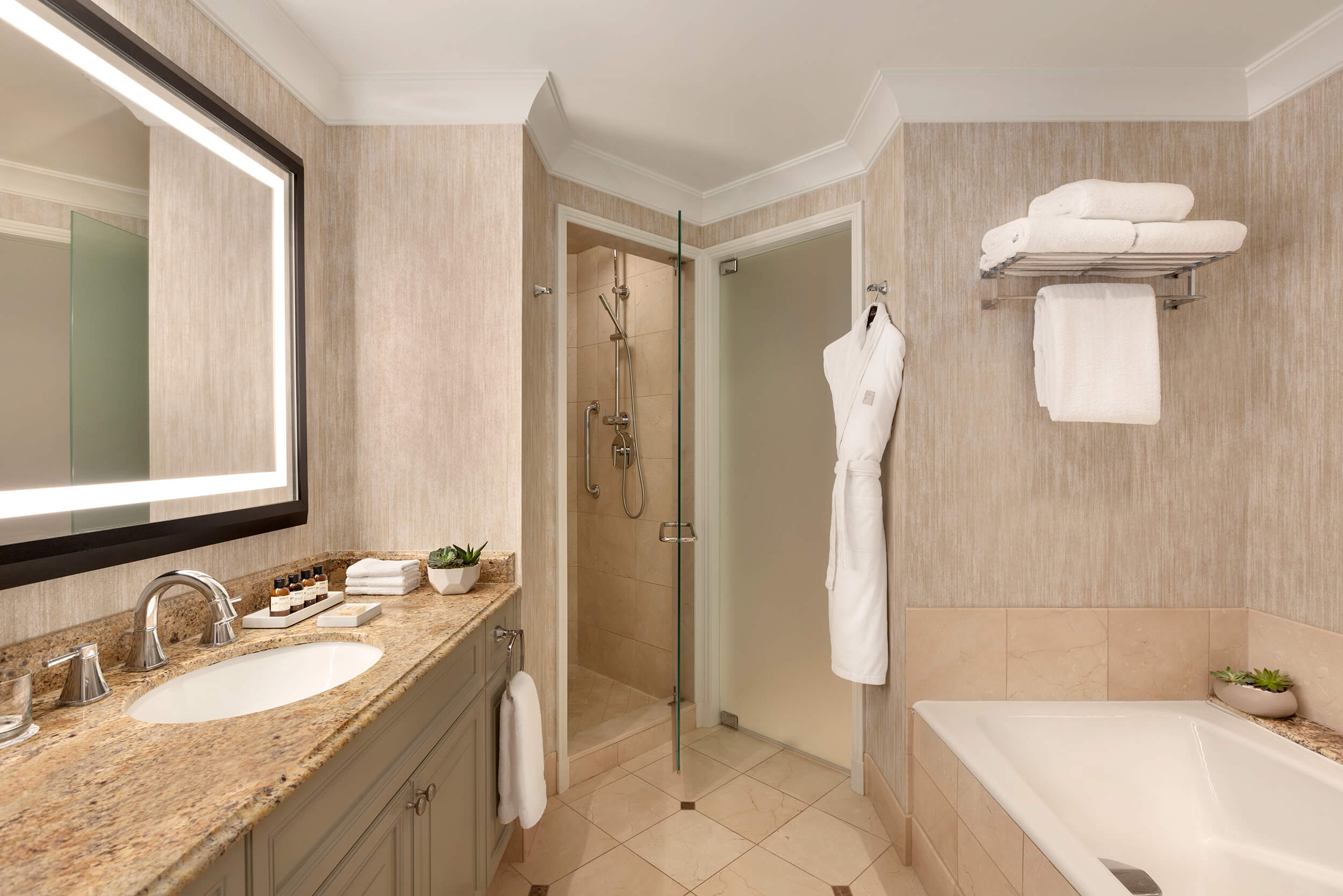 bathroom with bathtub and a white robe hanging on the wall