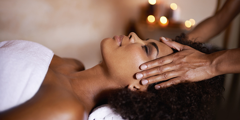 a woman with brown hair gets a head massage