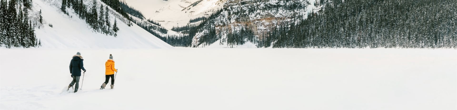 two people snowshoeing on lake louise