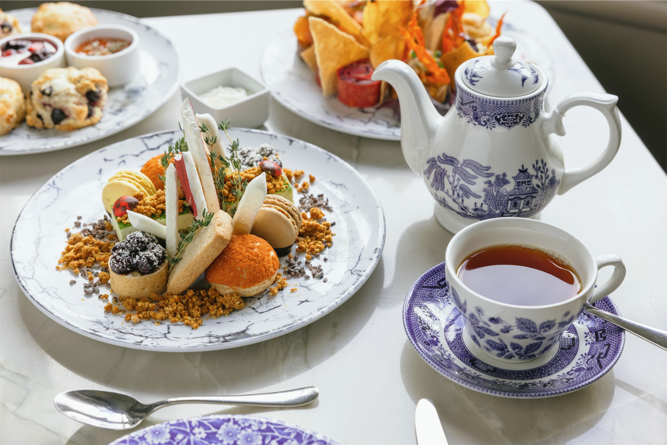 tea time tables-cape with three plates of small desserts