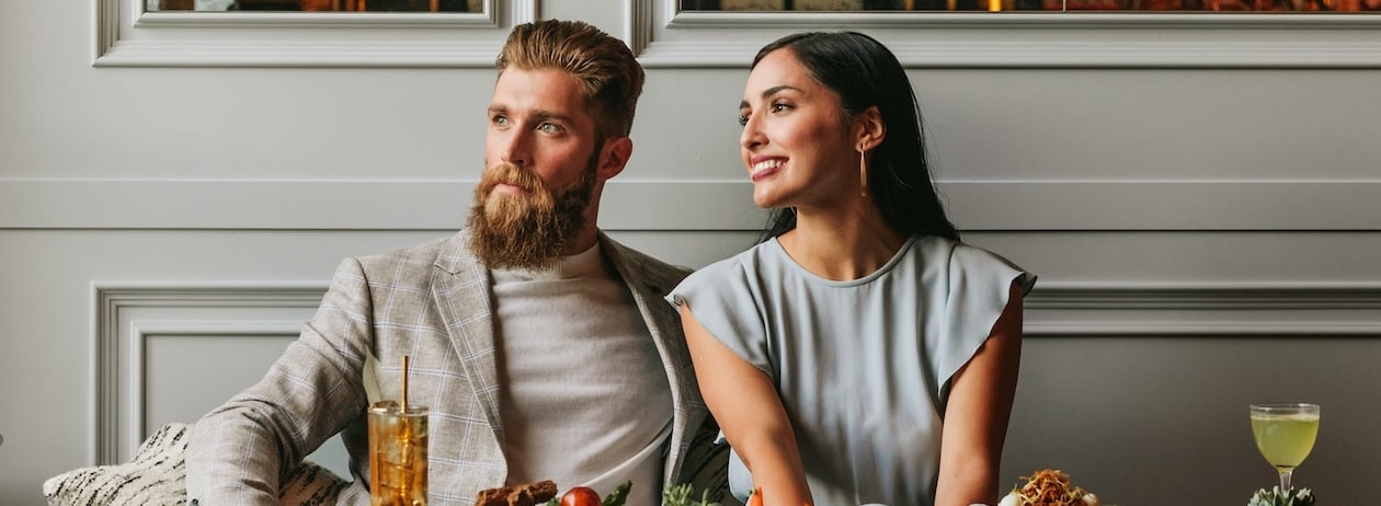 couple looking out the window while eating dinner
