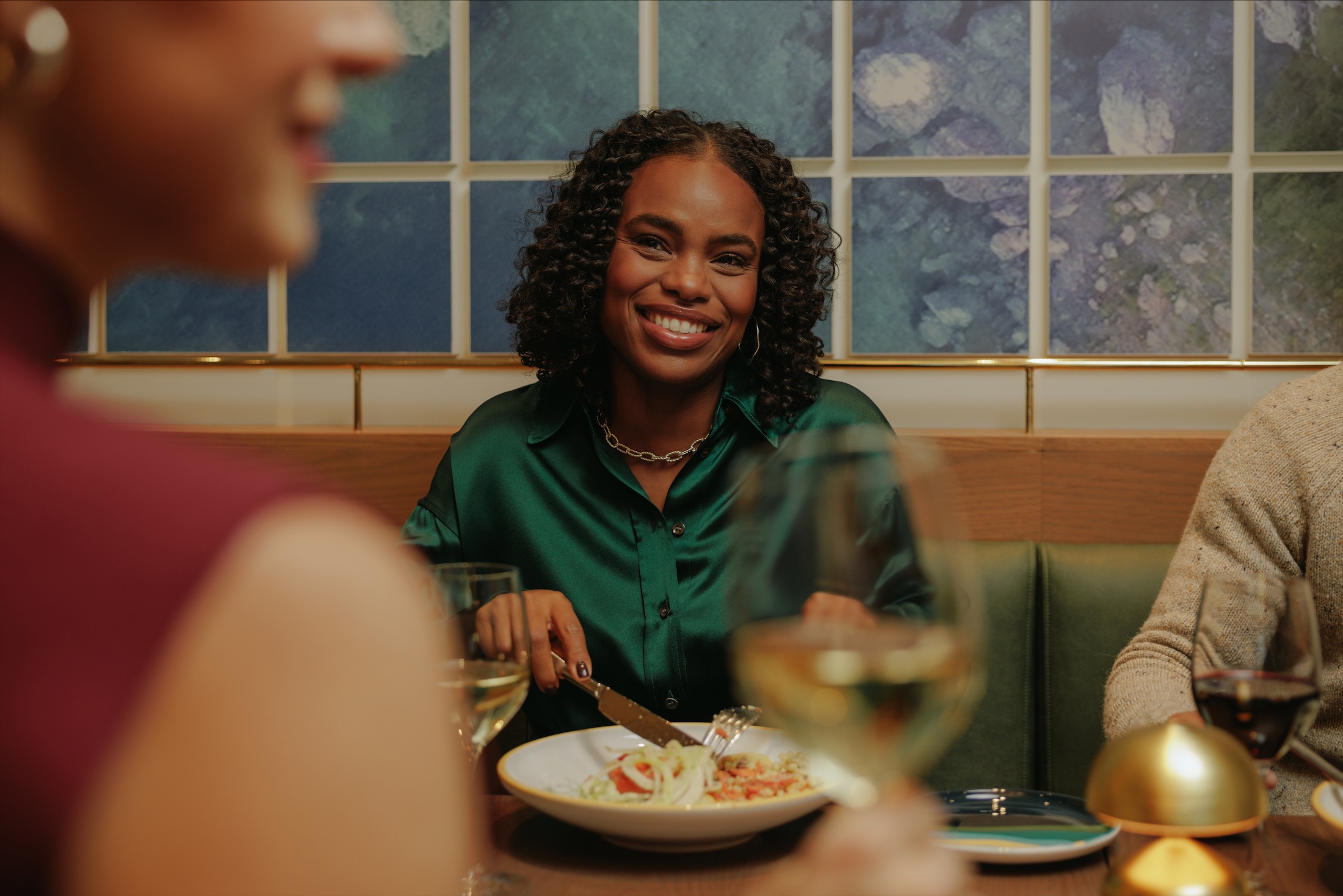 A woman smiling at her dinner companions at a restaurant table