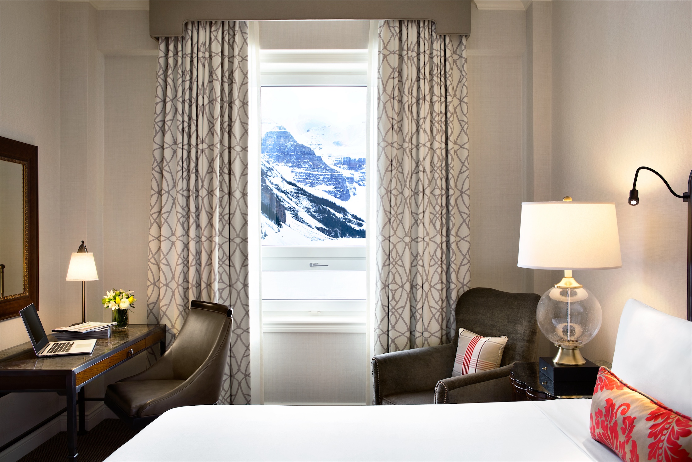 bedroom with desk and chair overlooking snowy mountains