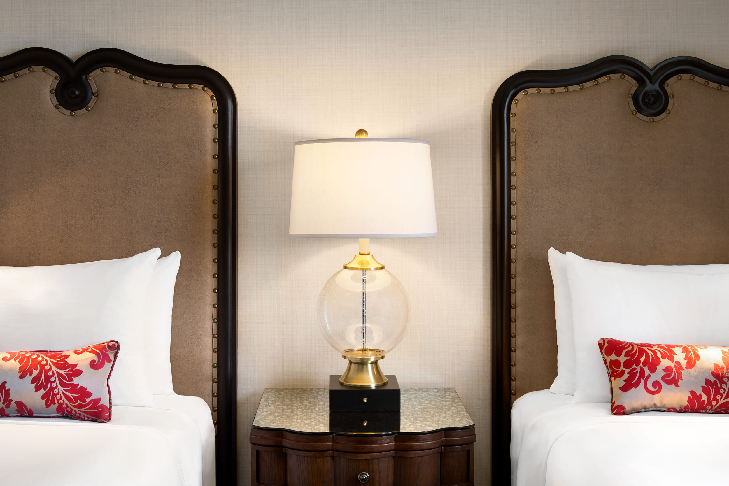 close up of two beds with a nightside table in between