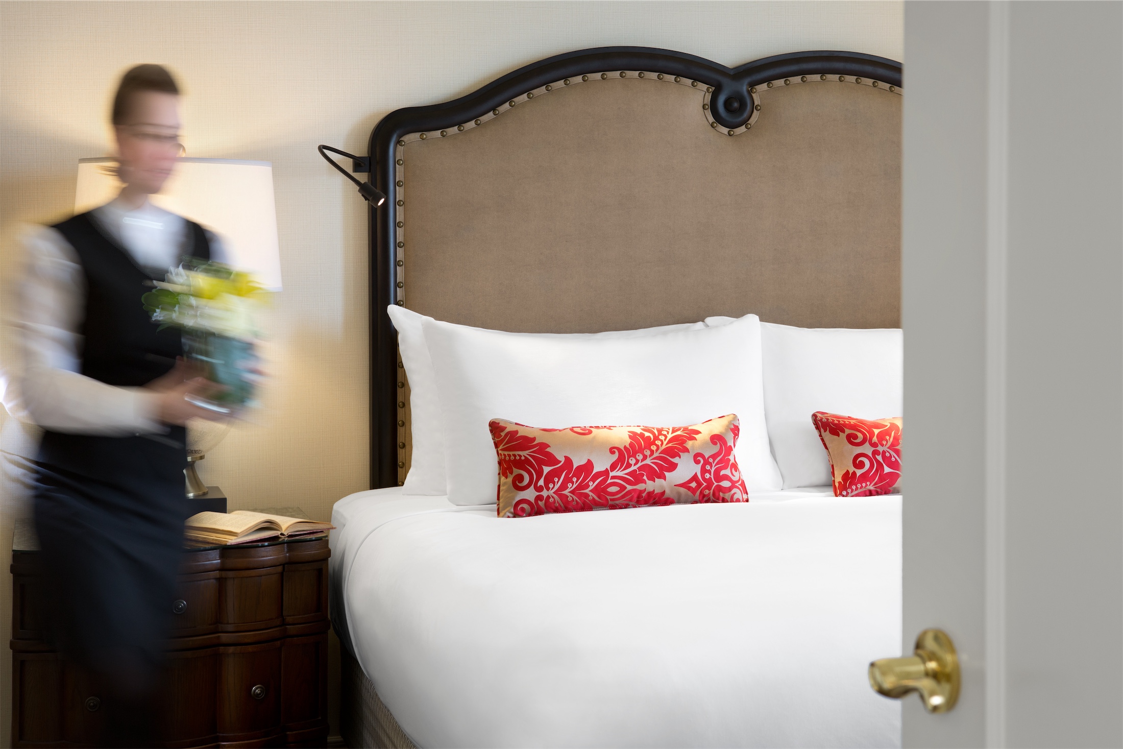 a housekeeper bringing a flower to the bedside table