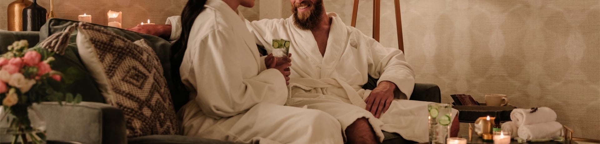 couple in robes sitting in their room drinking cucumber water