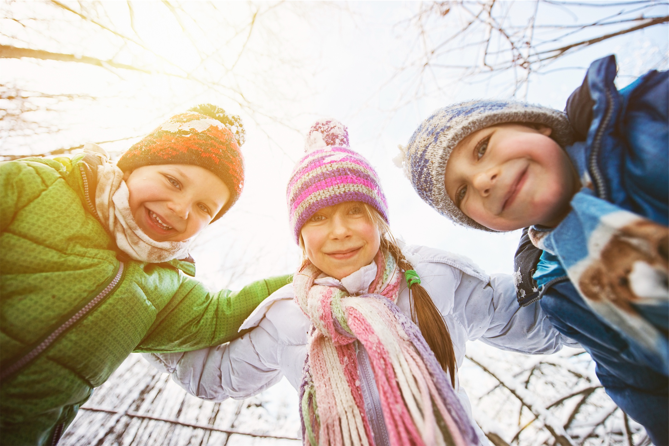 children in winter gear looking down at the camera