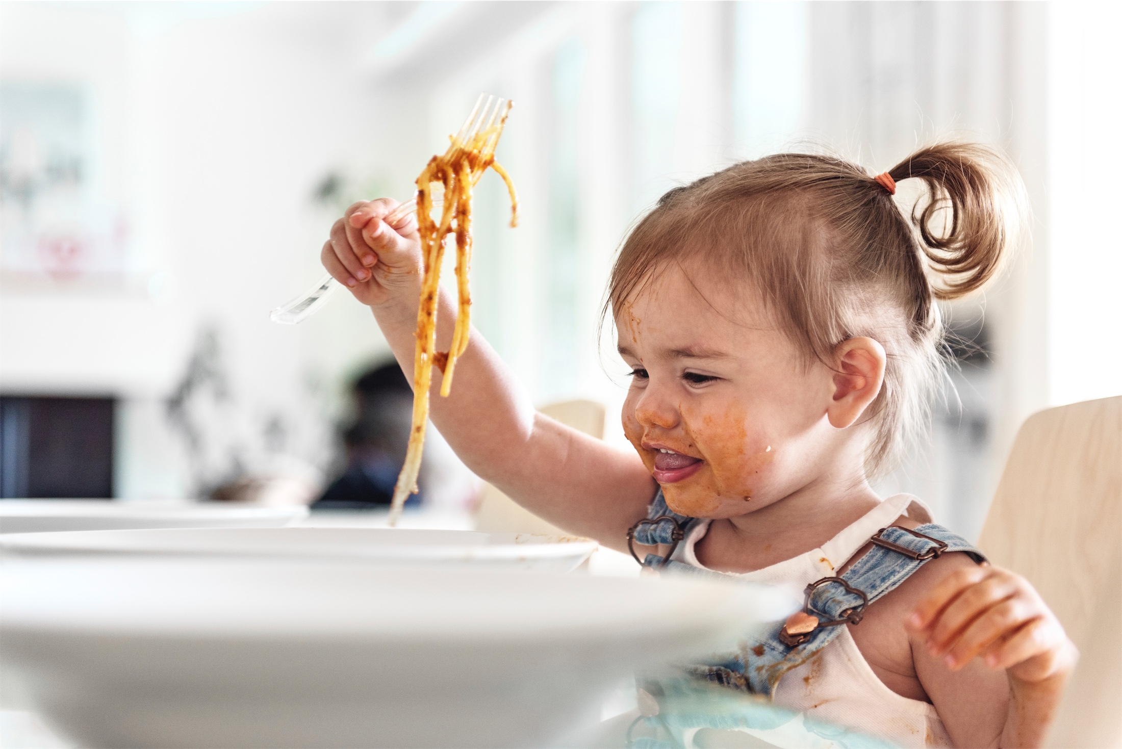 little girl eating spaghetti