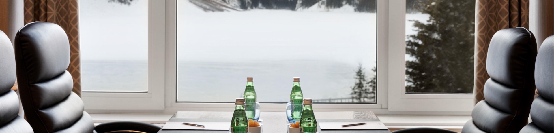 A meeting table near a large window with mountain views