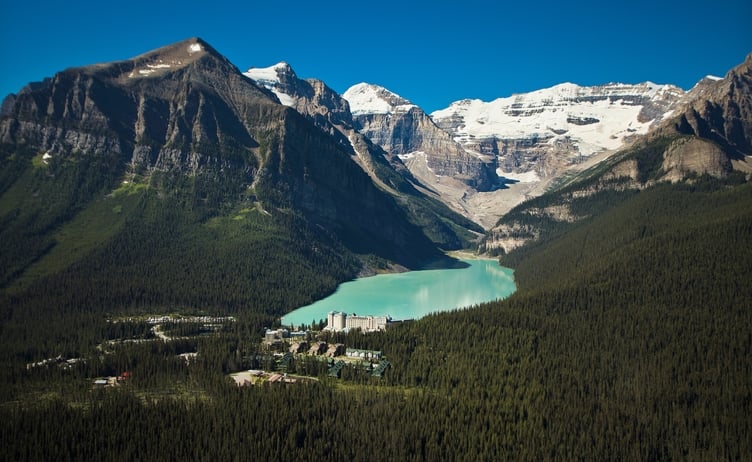 A distant shot of Fairmont Chateau Lake Louise surrounded by mountains