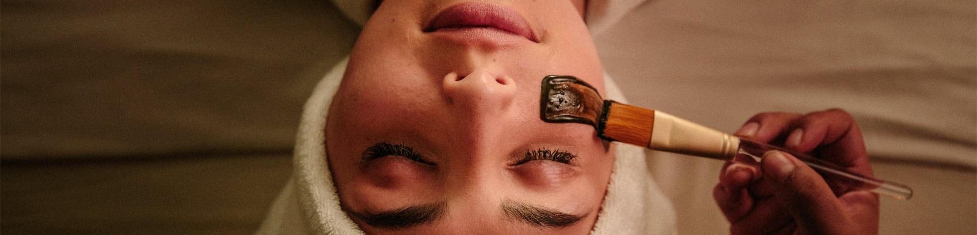A woman on her back getting a mud mask