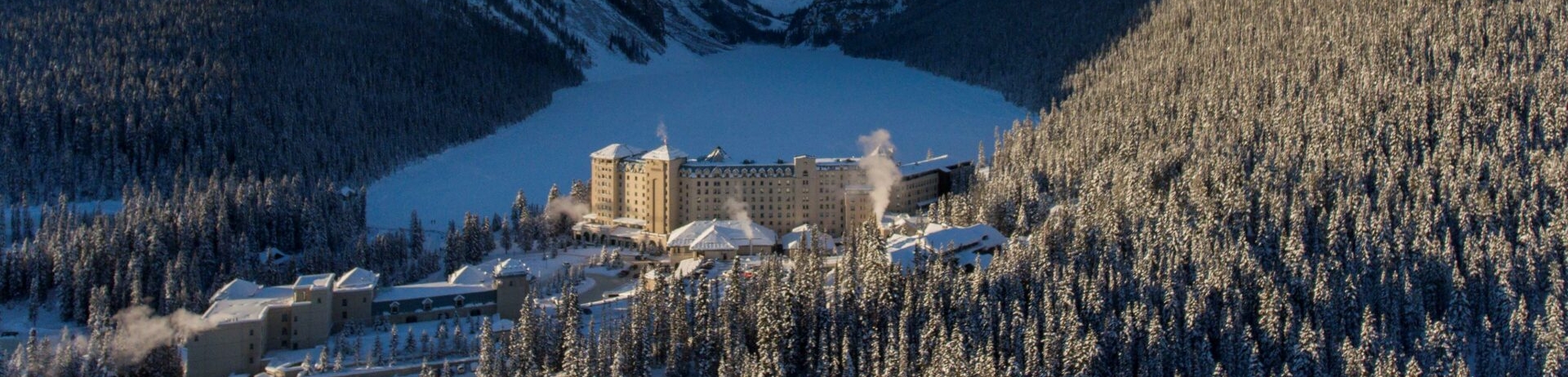 Fairmont Chateau Lake Louise surrounded by mountains in the winter