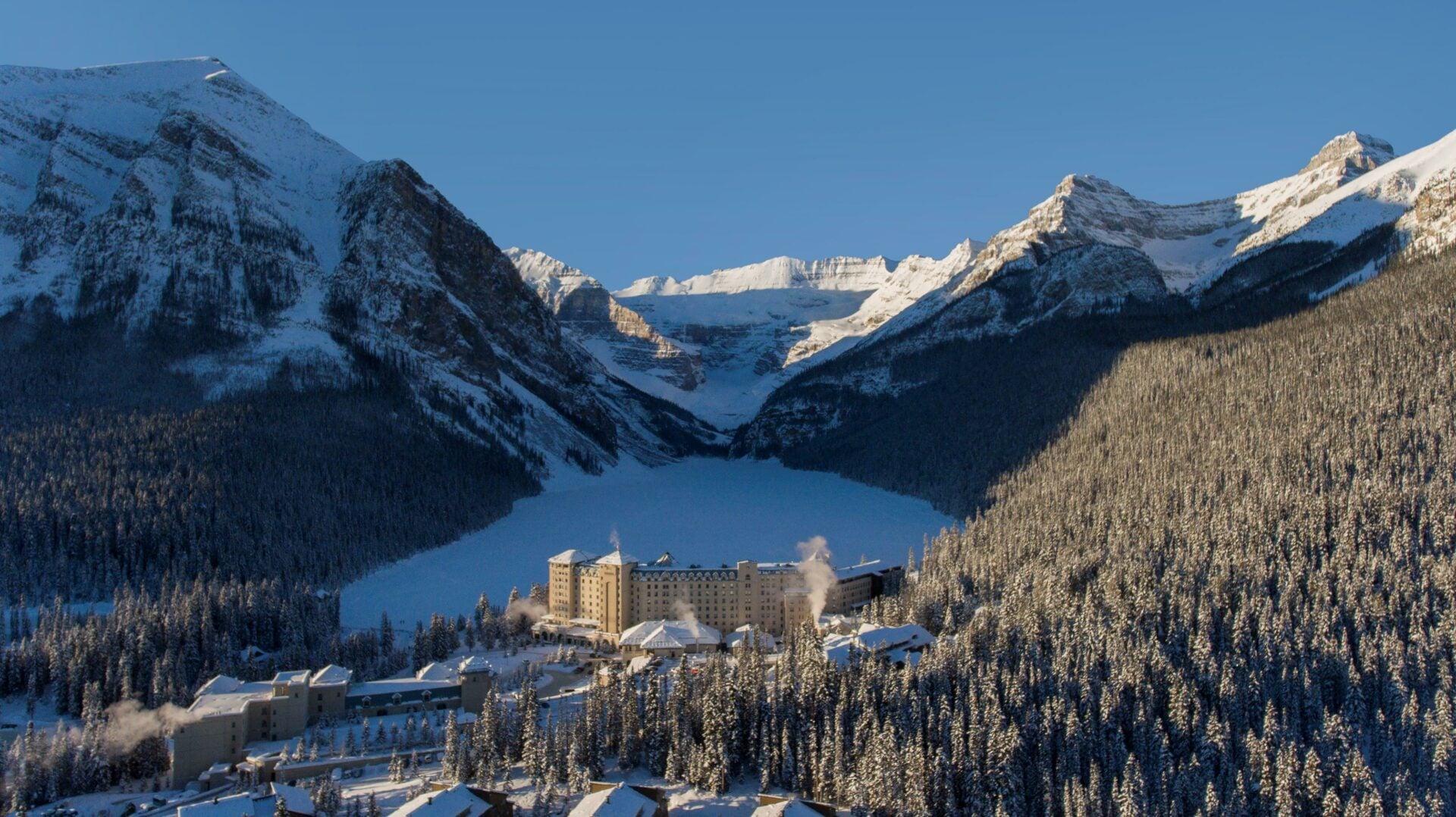 Fairmont Chateau Lake Louise surrounded by mountains in the winter