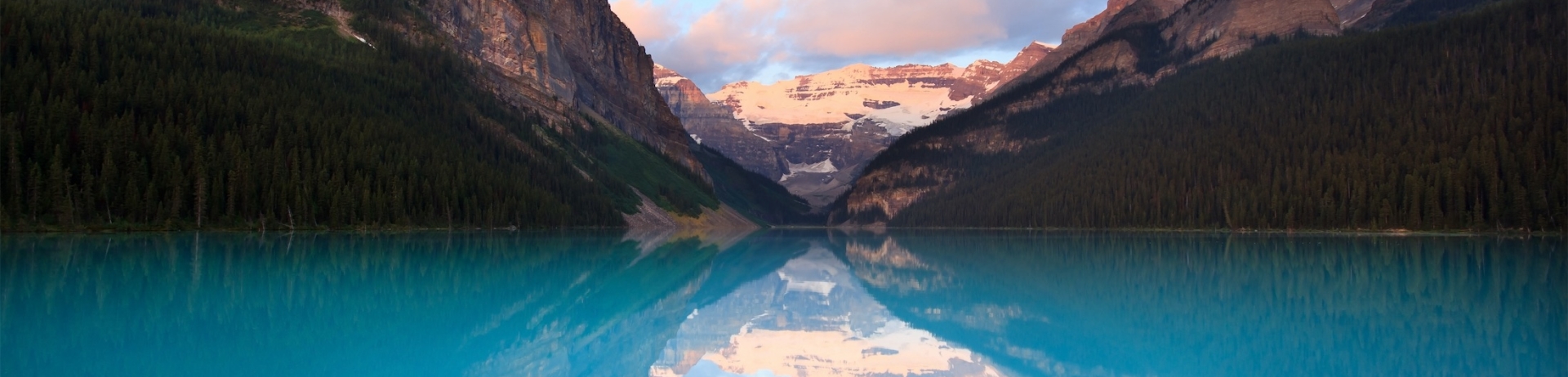 edge of lake with mountains in the background