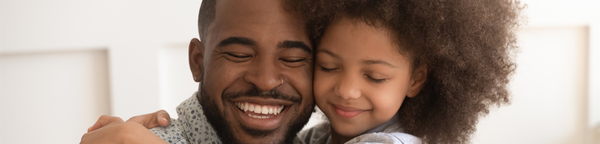 girl hugs father while holding a card with heart on it