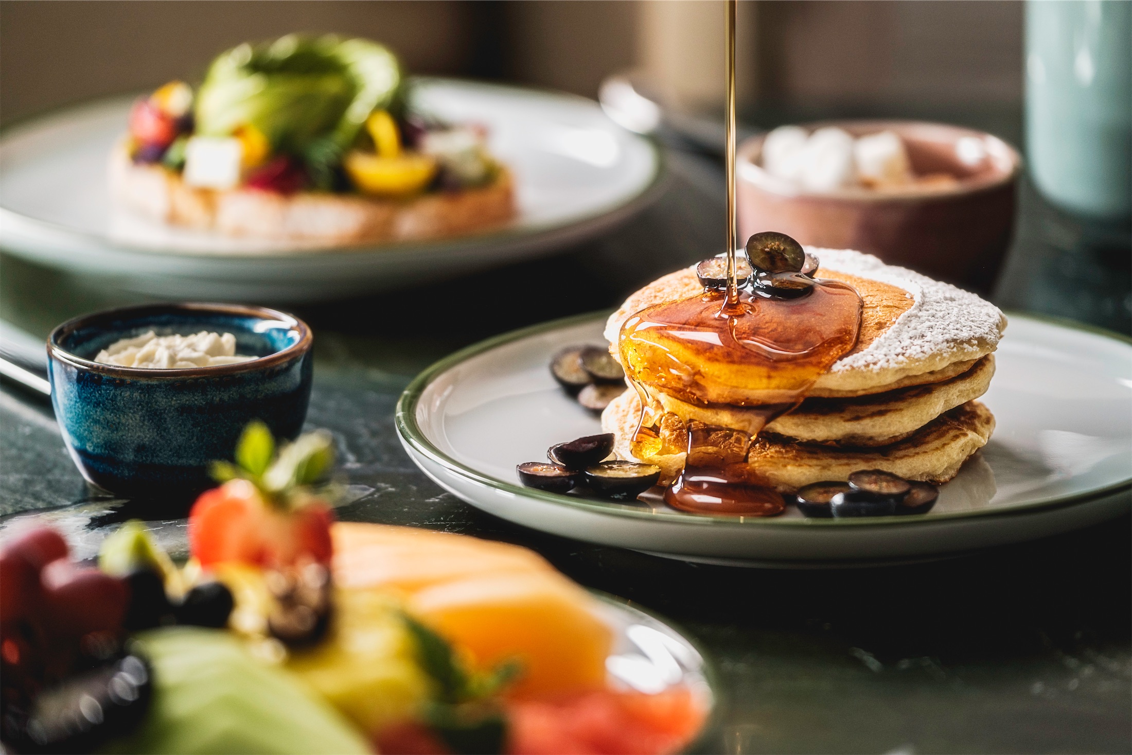 maple syrup being poured on pancakes