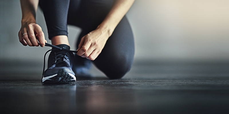 Cropped shot of a woman tying her shoelaces before a workout