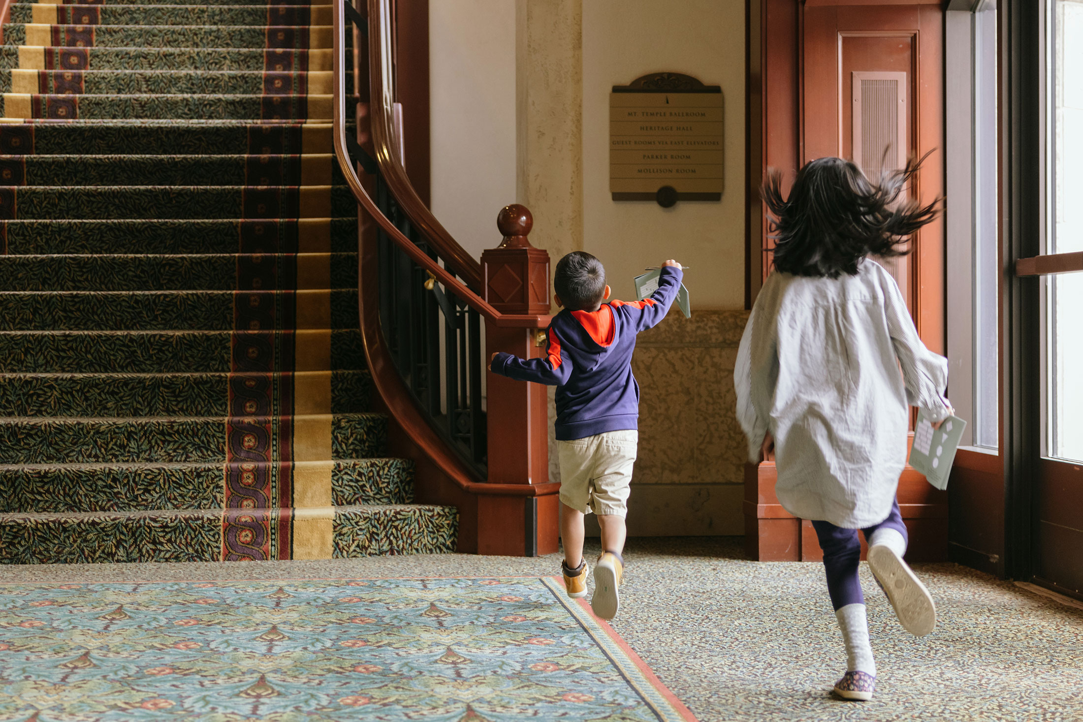 two children running down a corridor