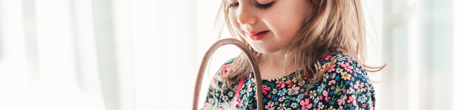 little girl holding a basket full of plastic Easter eggs
