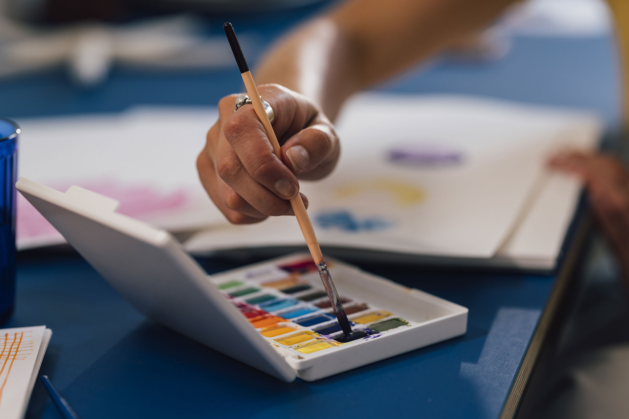hand collecting paint on a paintbrush