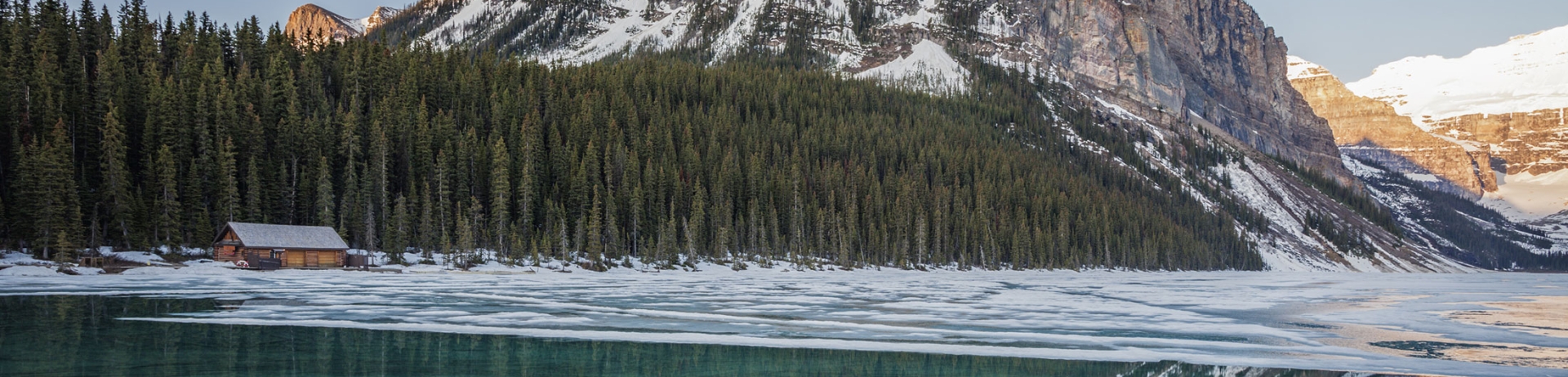 Photo of Fairview Mountain with ice on lake melting and the cabin in the distance