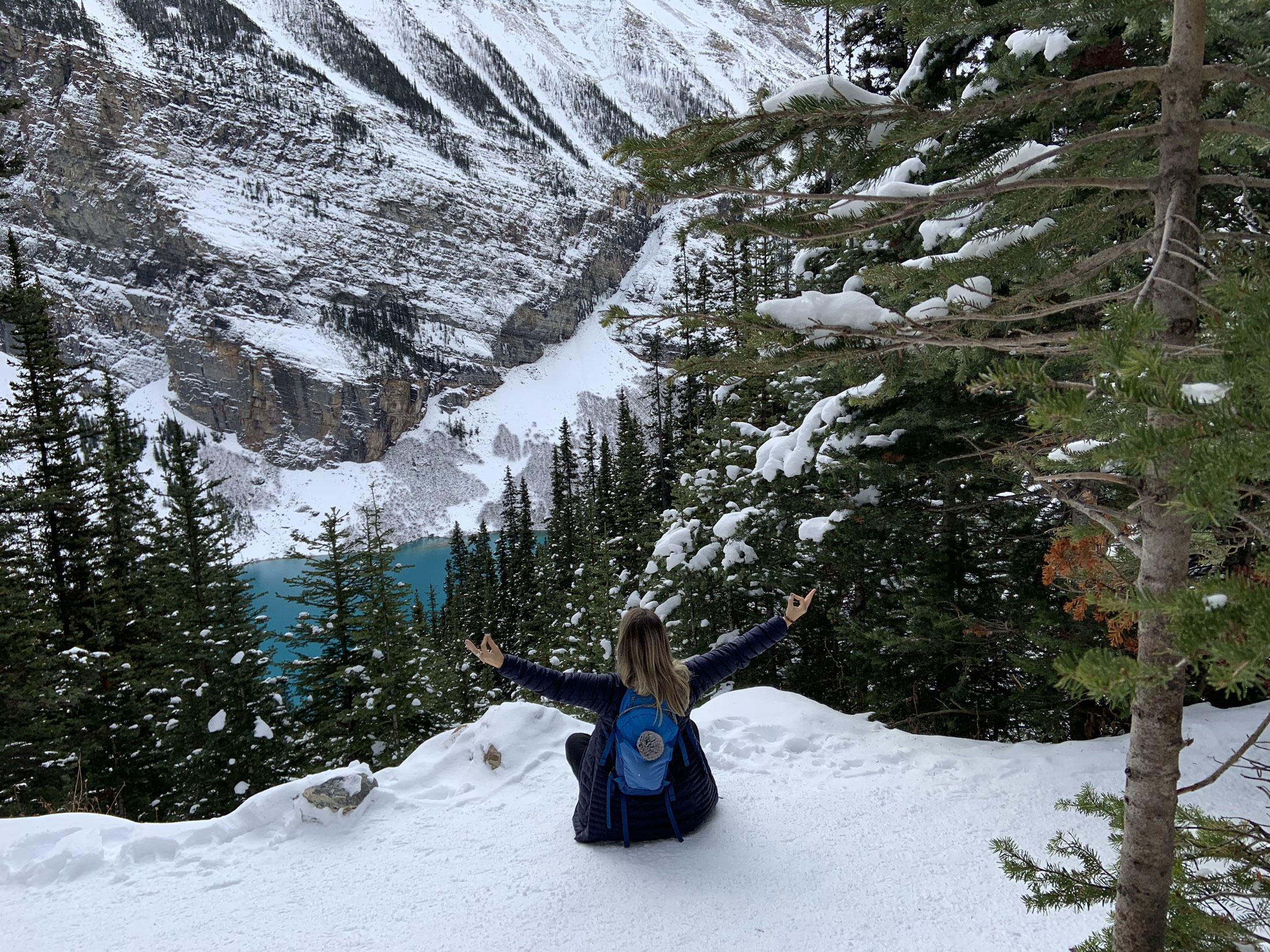 Woman sitting in the snow over looking Lake Louise