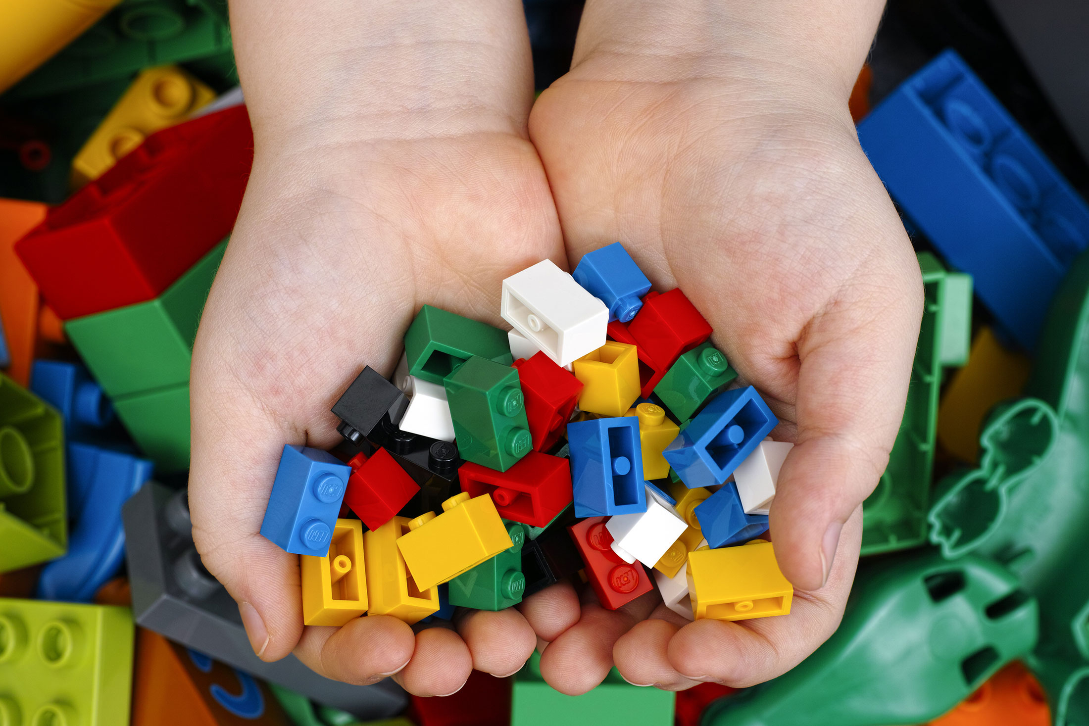 Childs hands holding small lego bricks