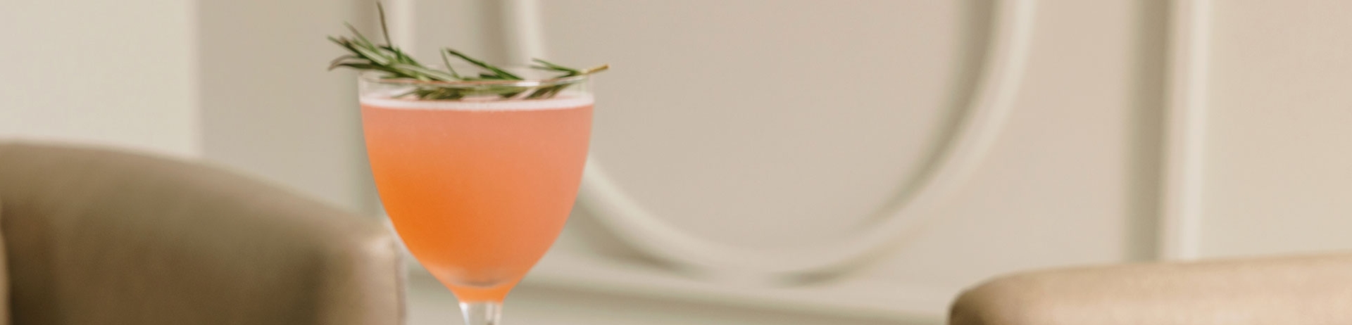 Rhubarb Gimlet cocktail with a rosemary sprig accompanied by seared scallops