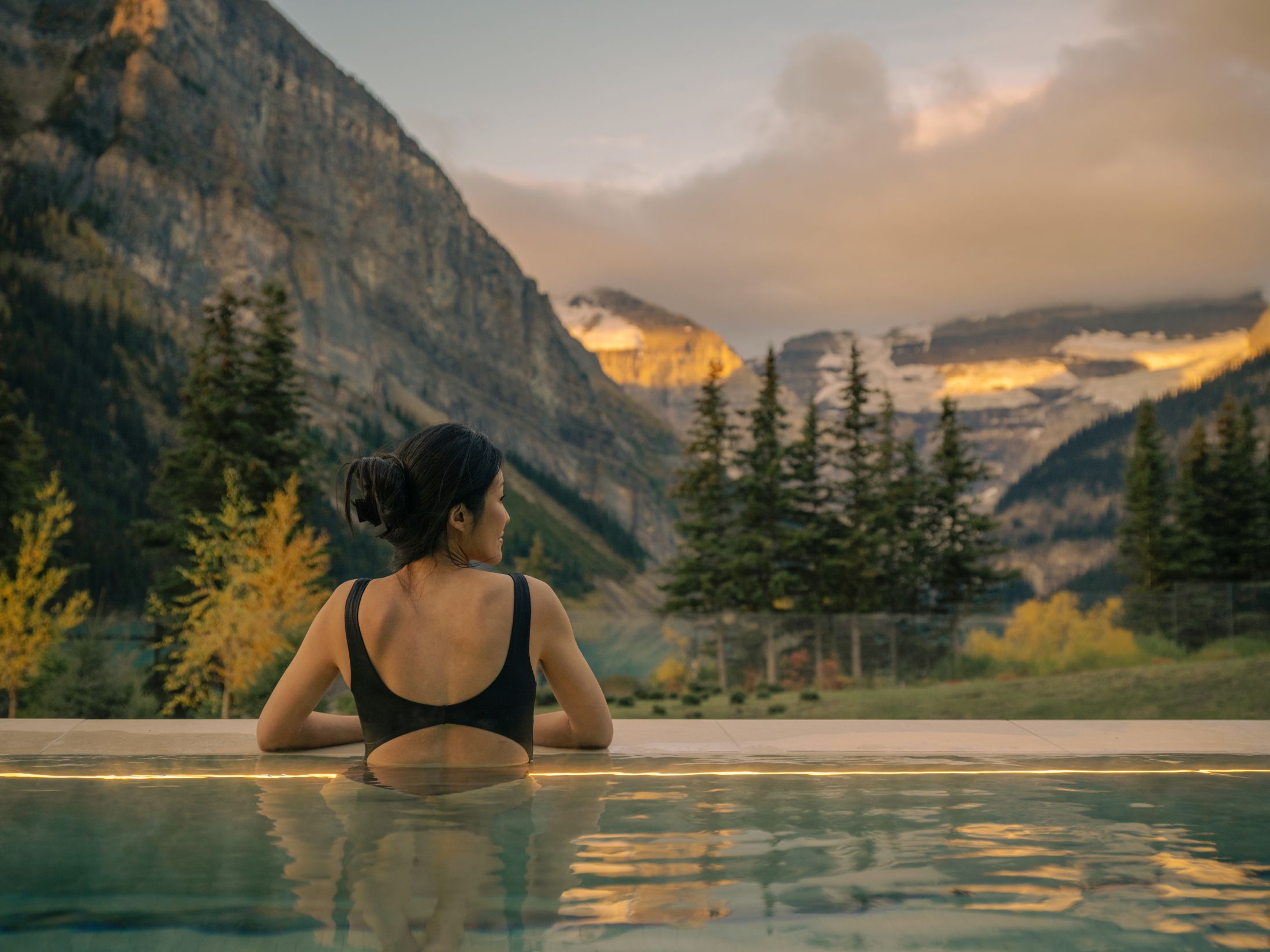 Female sitting in pool overlooking Victoria Glacier.